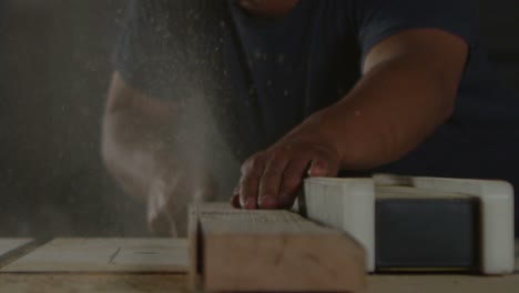 a woodworker saws a plank on a workbench 1