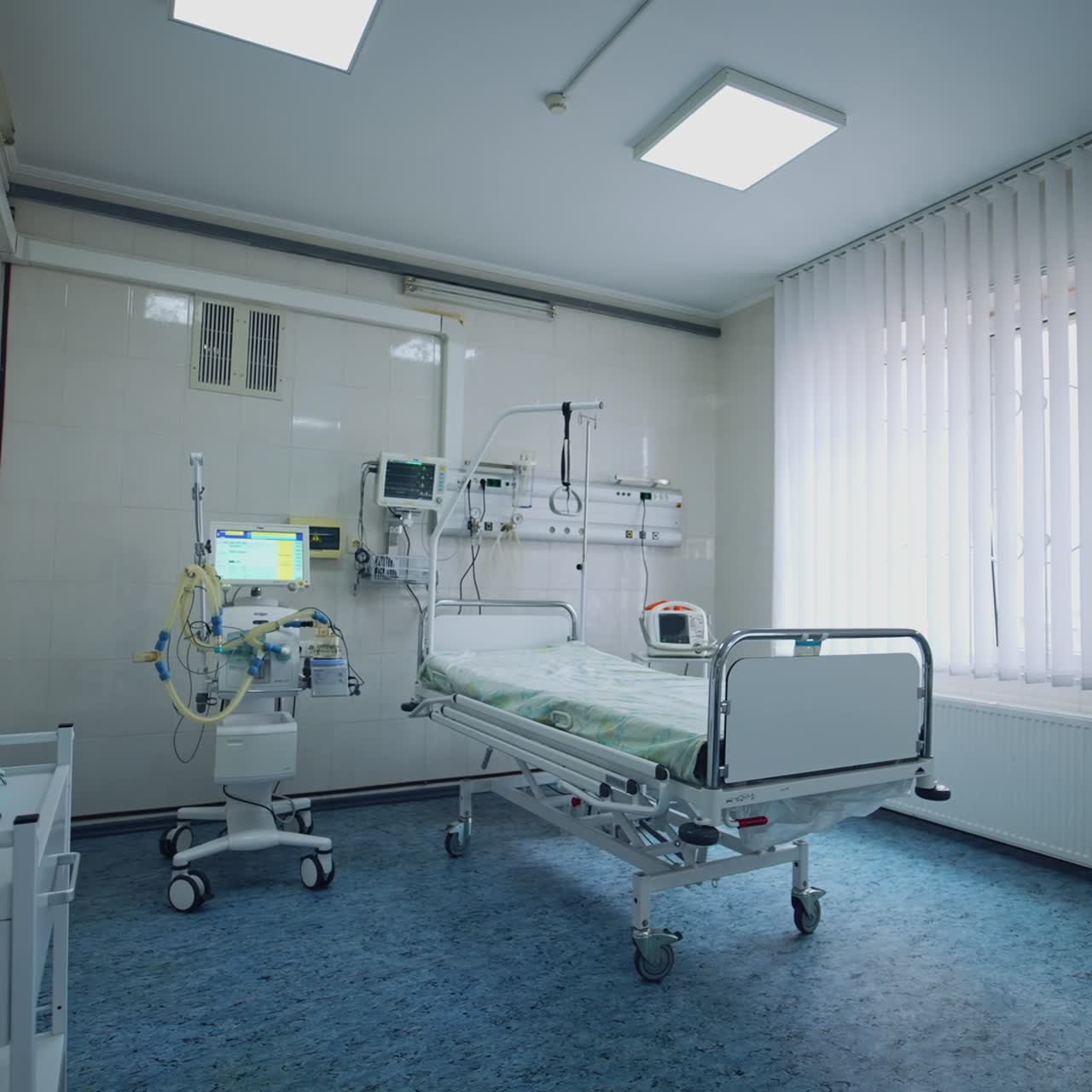 Sala de reanimación vacía en la clínica. Cama de hospital en la unidad de cuidados intensivos con equipo médico moderno. Sala de emergencias limpia.