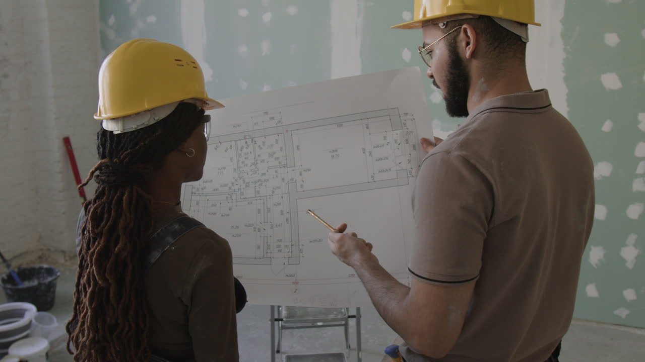 Construction workers reviewing blueprints on site