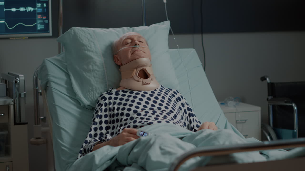 Patient with cervical collar for neck laying in hospital ward
