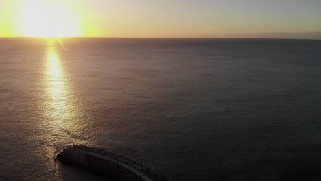 Luftaufnahme-Des-Goldgelben-Sonnenuntergangs-über-Dem-Meerwasser-In-Richtung-Horizont