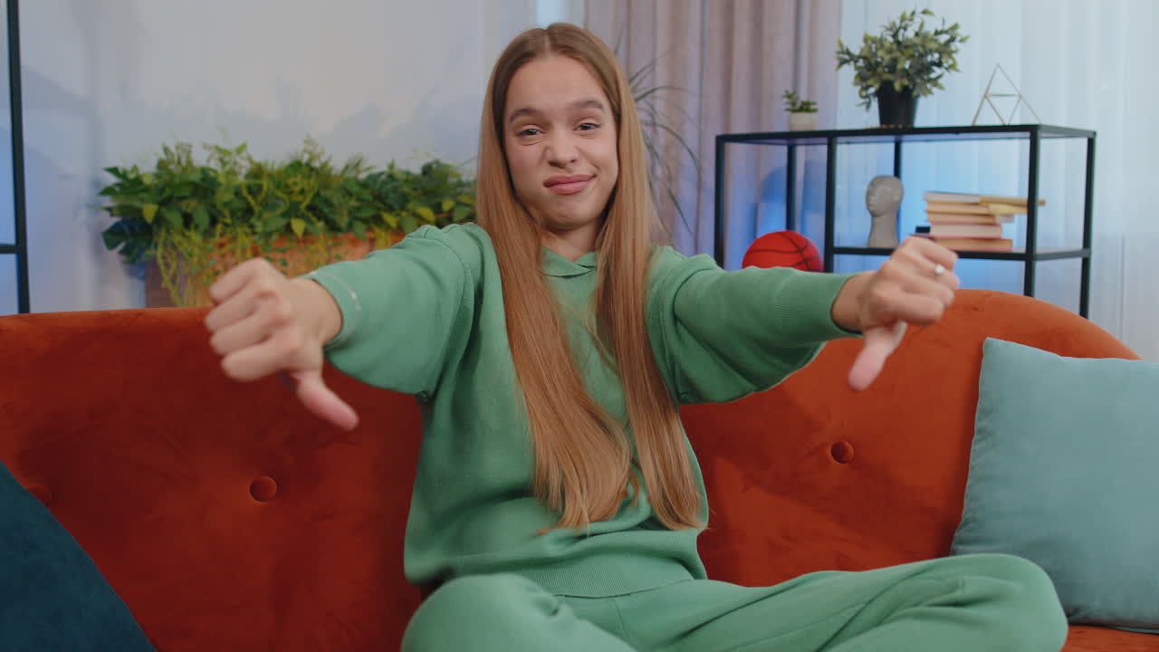 chica joven molesta mostrando pulgares hacia abajo, no le gusta el mal trabajo, desaprobación, retroalimentación insatisfecha en casa