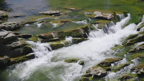Ein-Wunderschöner-Bergfluss-Das-Wasser-Kocht-Auf-Den-Felsen-Die-Draufsicht-4k-Zeitlupenvideo