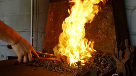 Female-metalsmith-heating-horseshoe-in-fire-4k