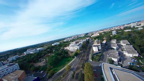 fpv aerial view of montpellier, going between the buldings following the cars driving on the street