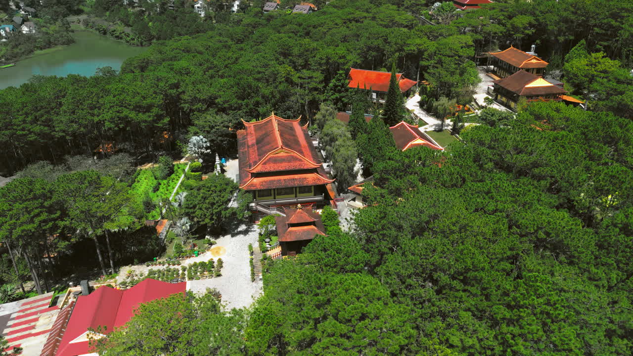 Aerial flyover of the serene Truc Lam Monastery, a Buddhist temple nestled in lush greenery, exuding peace and spirituality. Perfect for cultural or travel projects