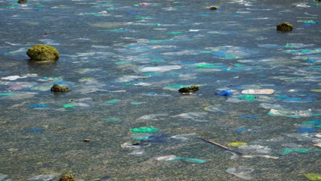 Bolsa-De-Plástico-Y-Botella-Flotando-En-La-Superficie-Del-Agua-Del-Mar-Del-Océano,-Desechos-Tóxicos-Del-Desastre-De-La-Contaminación