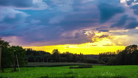 Imágenes-En-Timelapse-De-Nubes-En-Movimiento-Sobre-Un-Paisaje-Verde-Con-Un-Bosque-Oscuro-Al-Fondo