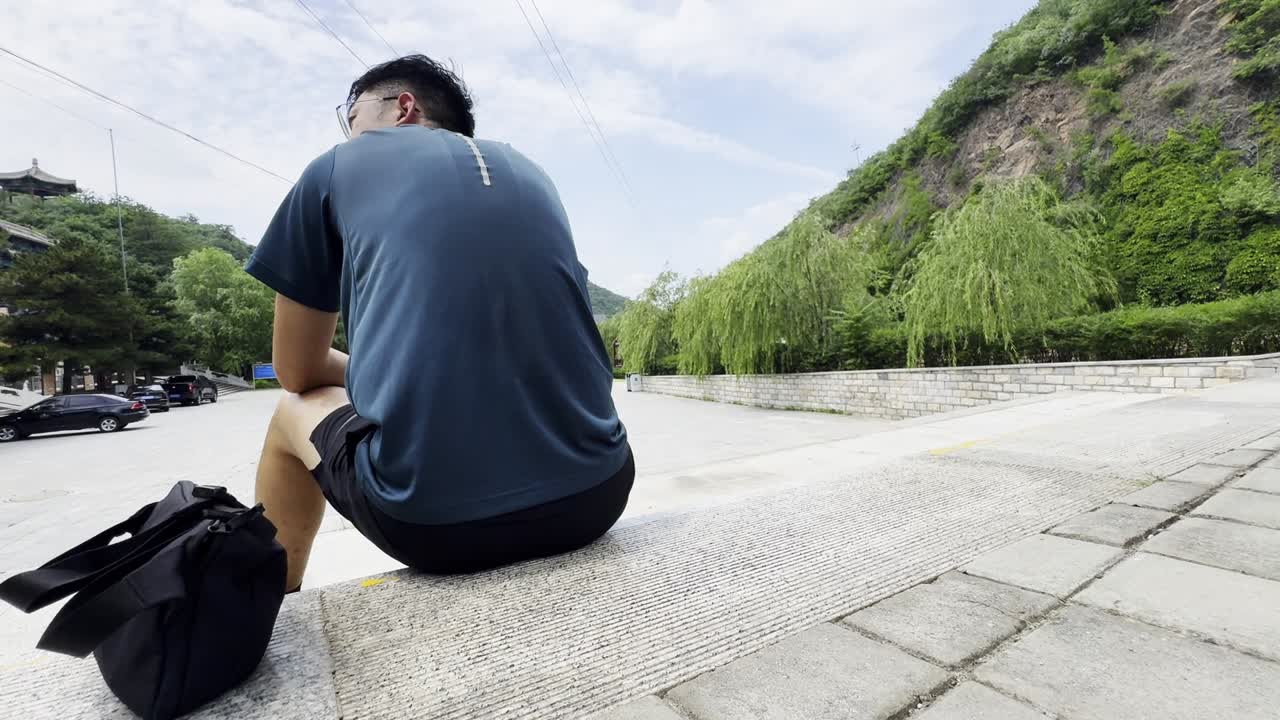 Man Sitting on Steps Contemplating Mountain View