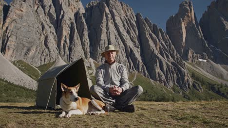 senior man and his dog relaxing in the mountains