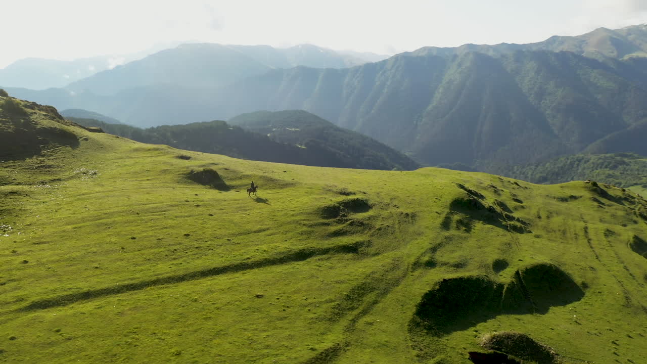 Riprese cinematografiche rotanti con drone di un uomo a cavallo nelle montagne dell'alta Omalo, Tusheti, Georgia