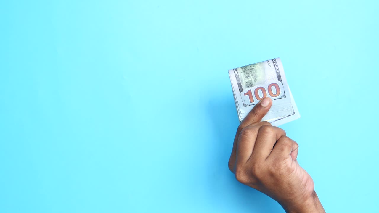 우리에게 100달러 지폐를 들고 있는 손