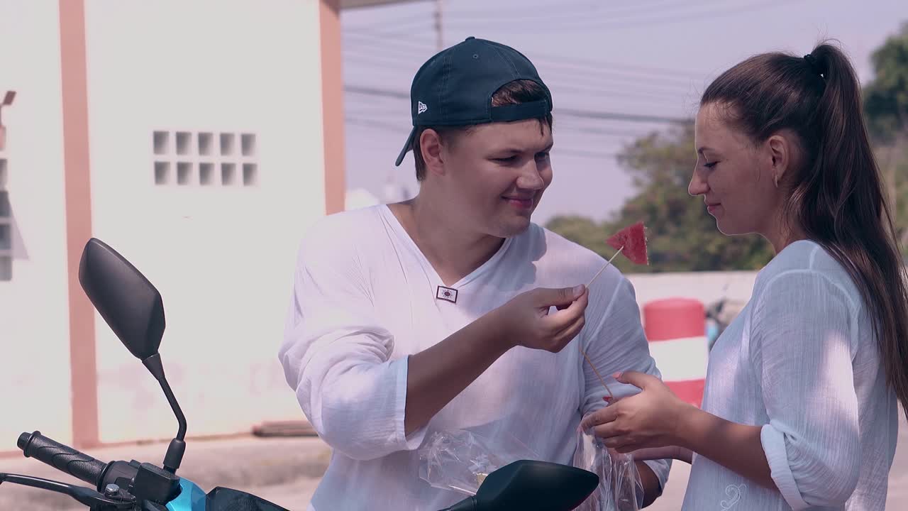 젊은 여성이 수박과 함께 플라스틱 가방을 들고 먹습니다.