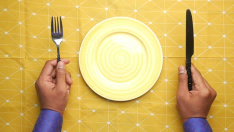 cutlery and empty plate on wooden background top down