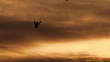 paragliding over the mountains at sunset