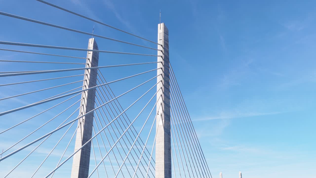 푸른 하늘을 배경으로 케이블에 늘어선 사장교 콘크리트 기둥을 낮은 시점에서 바라본 모습