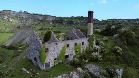 abandonado cubierto de hiedra desolado campo histórico galés costero fábrica de ladrillos molino vista aérea órbita media derecha