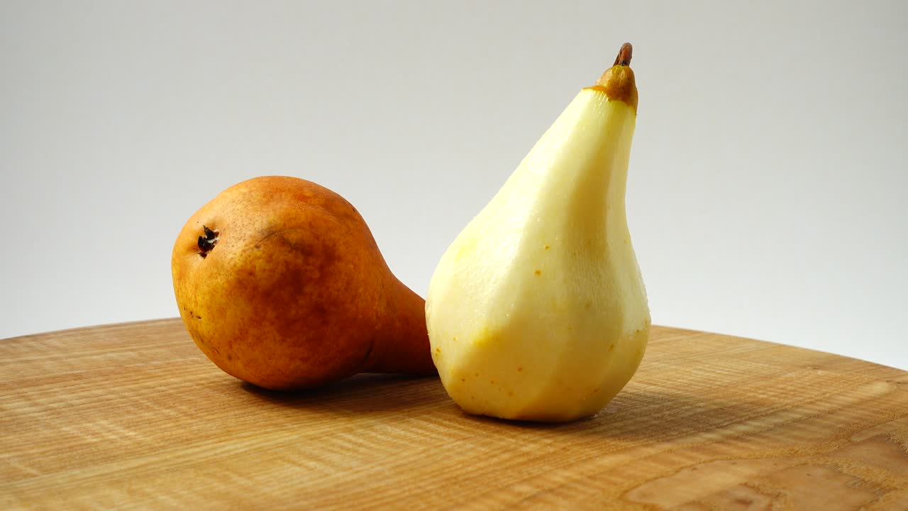 Pere su un tagliere di legno in cucina. Ripresa in movimento