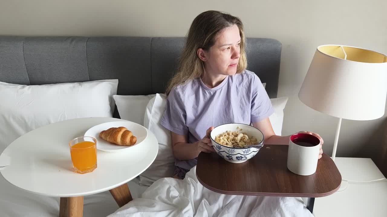 침대에서 아침을 먹는 여자