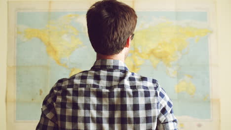 Joven-Turista-Mirando-El-Mapa-Mundial