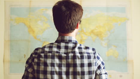 young tourist man looking at world map