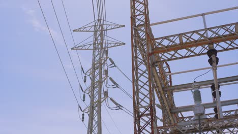 Low-angle-view-looking-up-at-power-lines-below-a-cloudy-sky