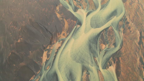 drone flying over scenic yellow riverbed in south iceland - aerial