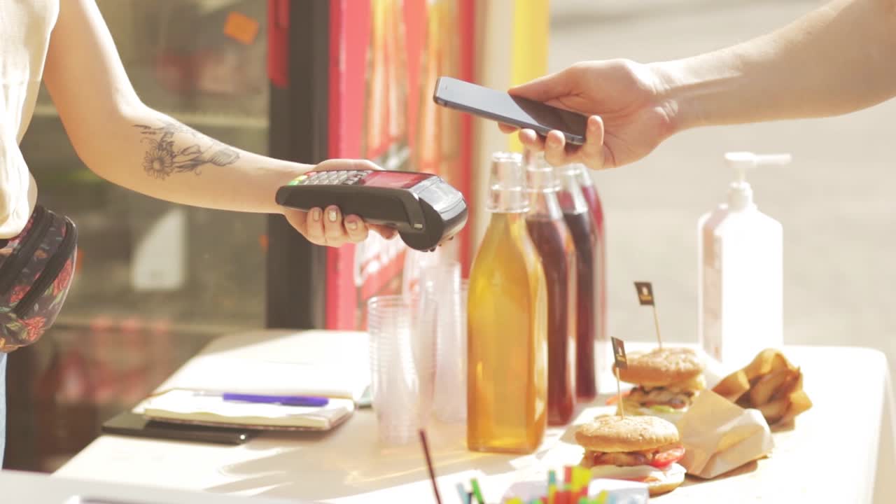 Tecnologia NFC, cliente faz pagamento com cartão de crédito contactless.