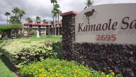 touristic resort kamole sands in hawaii welcoming tourists on apartments with ocean view, surrounded by green grassland, view from the main gate