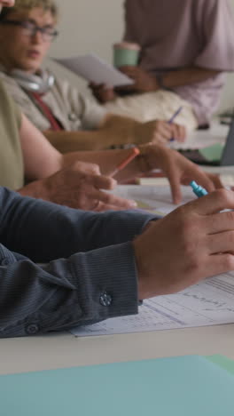people actively working and collaborating on documents at an office table