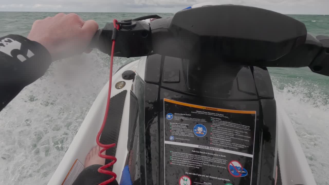 Rekaman POV seorang pengendara jet ski basah kuyup karena percikan balik ombak.