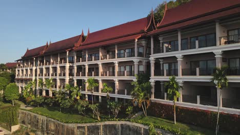 Slow-aerial-pan-of-a-large-red-roofed-resort-on-the-rainforest-island-of-Koh-Chang,-Thailand