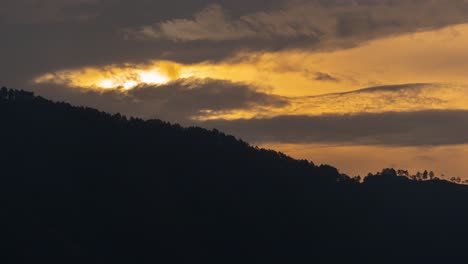 dramatic golden sky over silhouetted forest hillside