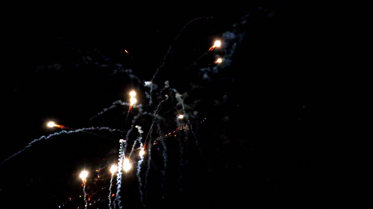 Volo al rallentatore attraverso fuochi d'artificio, cielo notturno, spettacolo emozionante e vibrante.