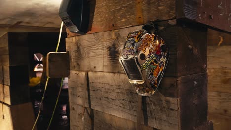 closeup of welding mask helmets hanging on stacked wood