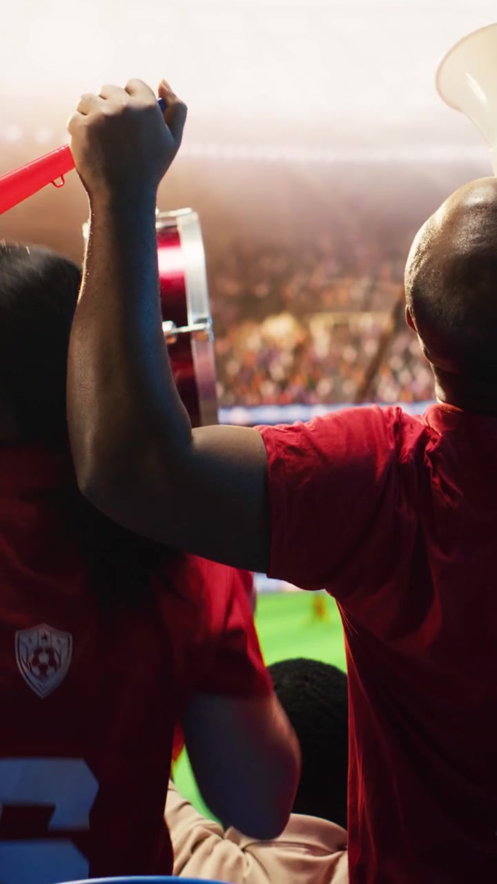 Video vertical: Primer plano de aficionados de fútbol alegres abrazándose en las gradas del estadio