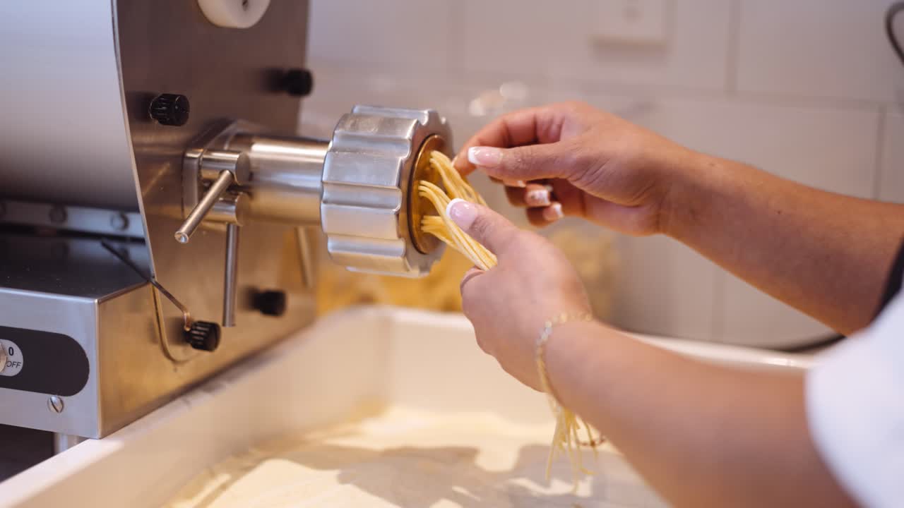 Cuoca che prepara spaghetti al rallentatore in cucina, primo piano