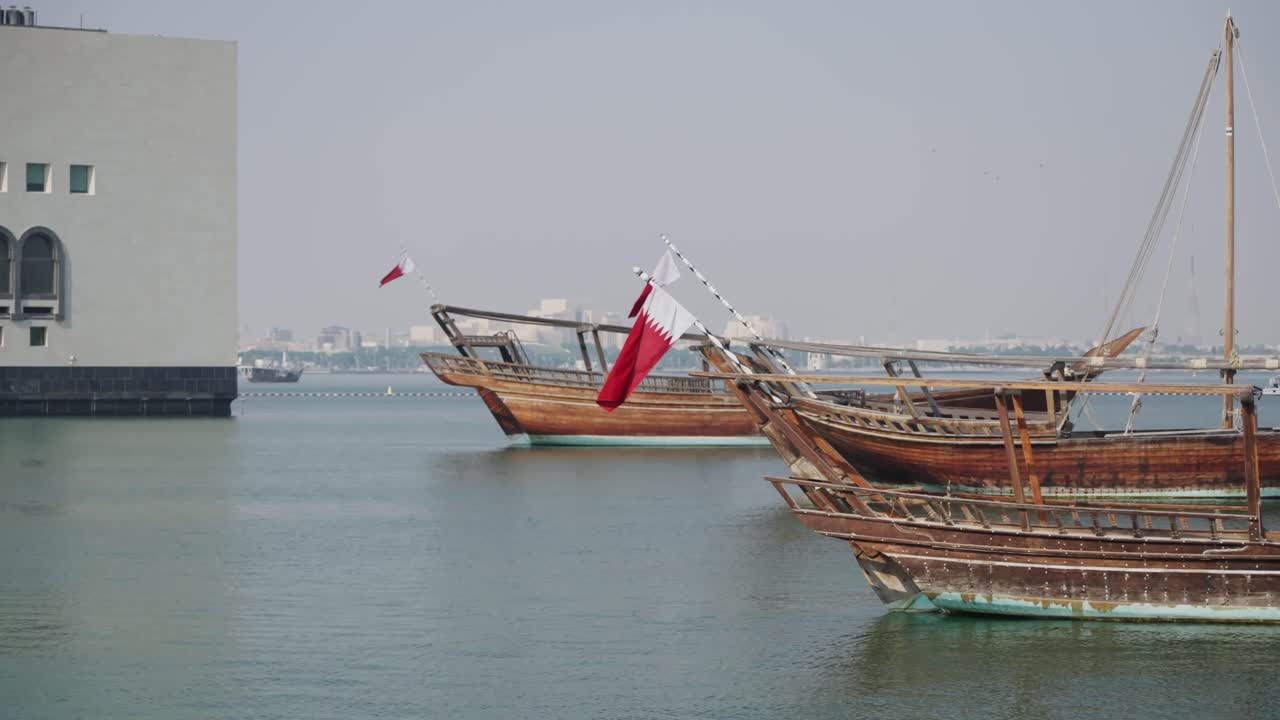 Bandiere del Qatar a lato delle barche oscillanti nel porto turistico di Doha
