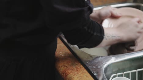 dirty plates being scrubbed in the sink