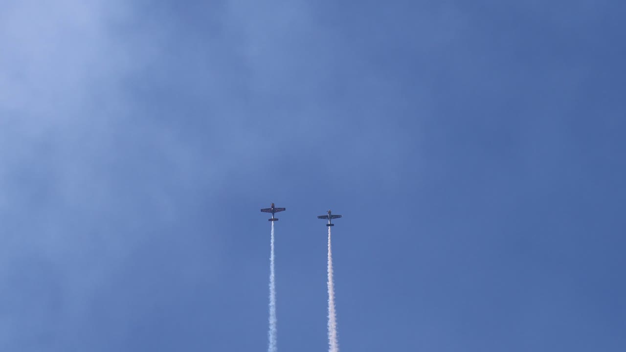 самолеты выполняют трюки с дымовыми следами в небе
