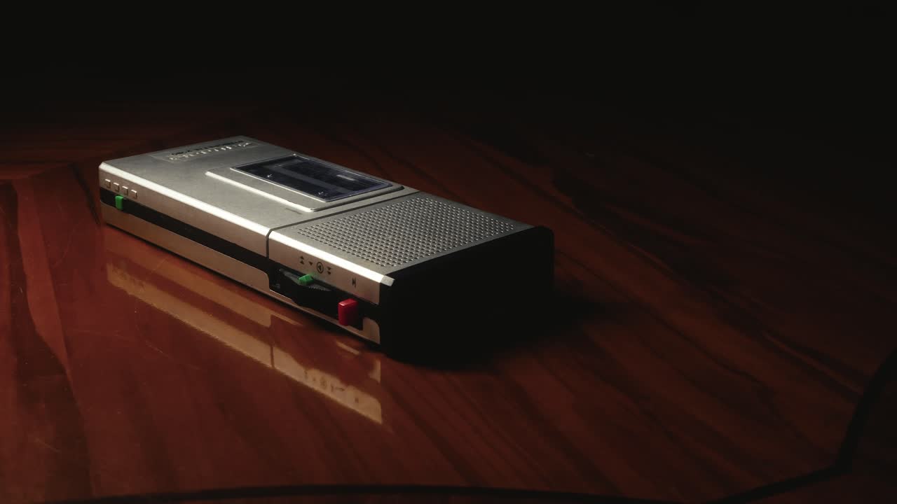 폴리시 된 테이블  에 놓인 카세트 디크타폰 을 둘러싼 느린 움직임