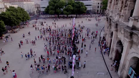 Drone-tilt-down-of-the-Arenas-de-Nîmes-during-the-day-of-people-queuing-to-return