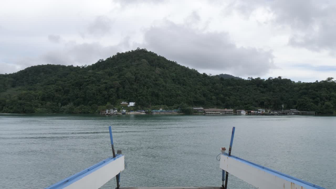 Ferry view to Koh Chang, serene waters, lush hills, cloudy day, travel mood