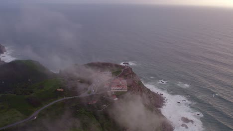 tilt up shot of the iconic lighthouse at cabo da roca with moody conditions, aerial