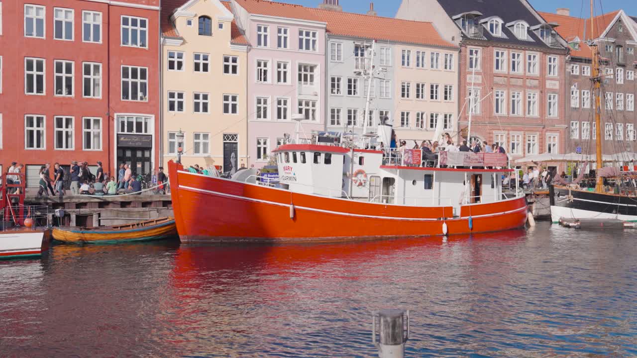 Ship parked near historic Nyhavn canal with colorful building exterior, Denmark
