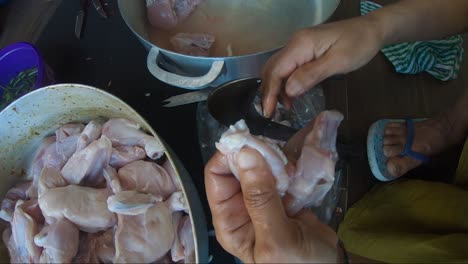 woman using traditional vegetable cutter to cut chicken pieces