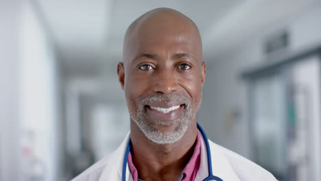 portrait of happy african american male doctor looking at camera and smiling, slow motion