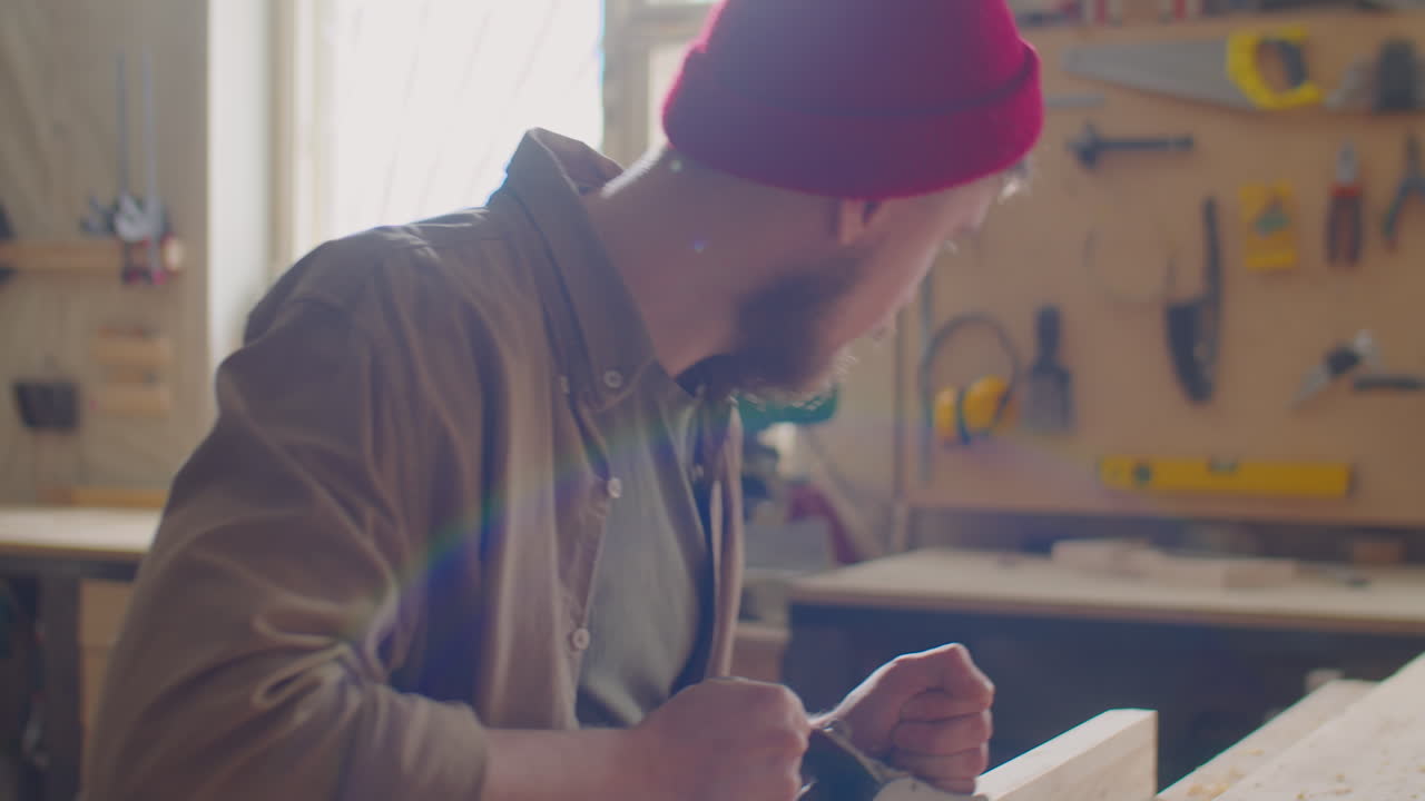 Woodworker Using Hand Plane in Workshop