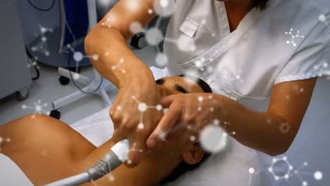 Animation-of-molecules-over-biracial-male-patient-and-female-doctor-during-laser-treatment