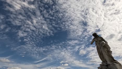 statue against a backdrop of fast-moving clouds.